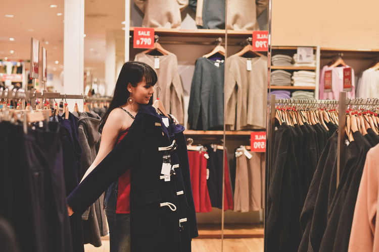 Young woman buying clothes in shopping mall