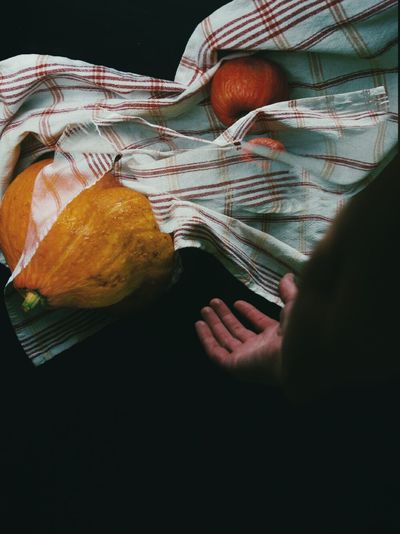 Close-up of hand, kitchen towel and pumpkin