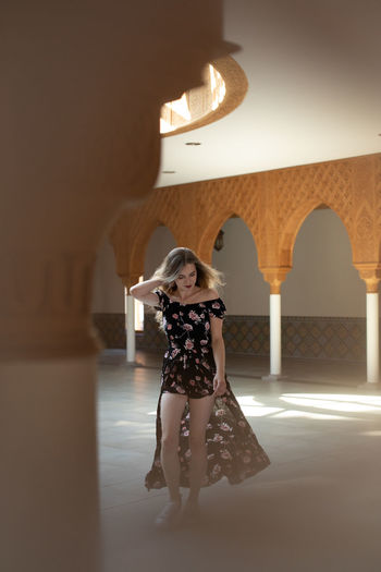 Full length of woman standing against building