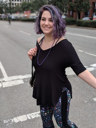 Smiling young woman walking on road