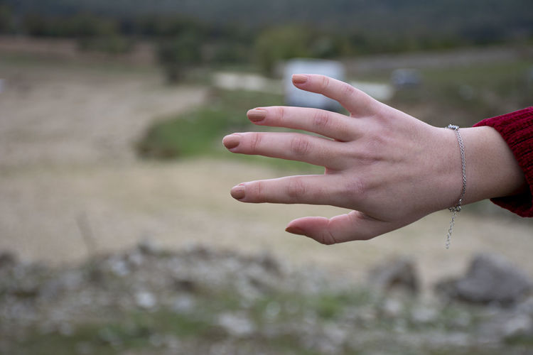 Close-up of woman hand on field
