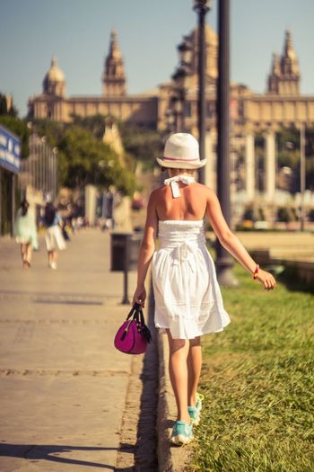 Rear view of girl wearing white dress while walking on street
