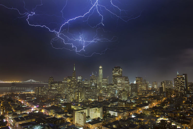 Illuminated cityscape against sky at night