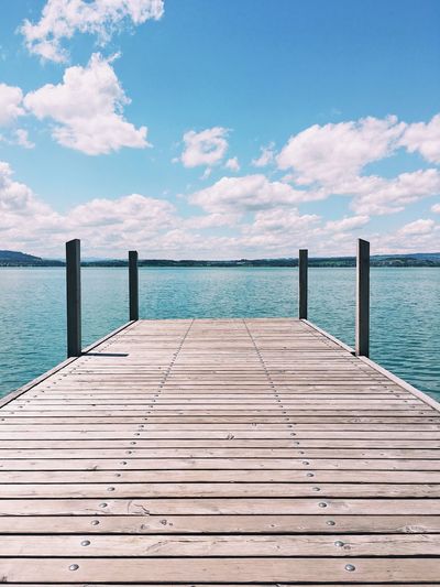 Pier over sea against blue sky