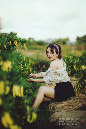 Portrait of beautiful woman harvesting chili at farm