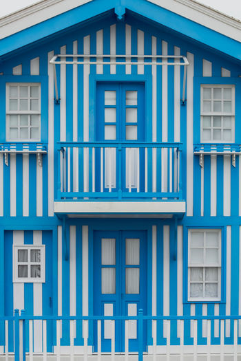 Typical colourful houses with blue and white stripes in costa nova - aveiro against sky