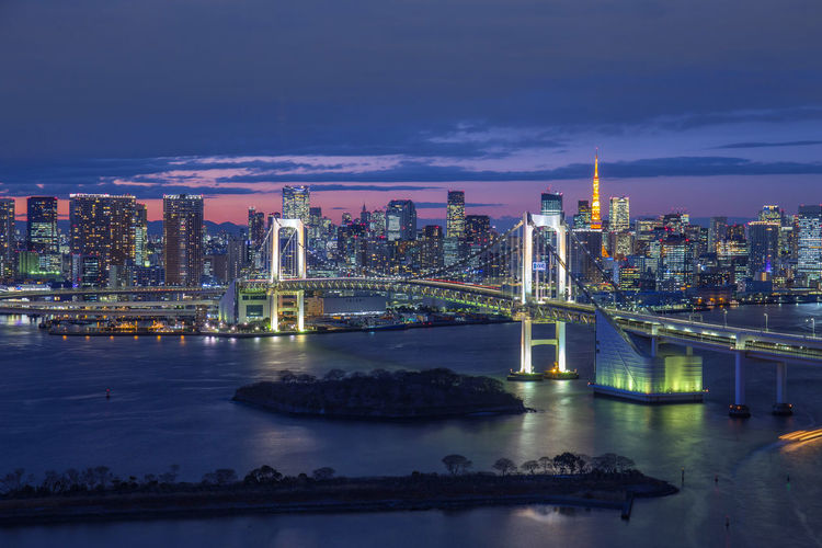 Illuminated rainbow bridge - tokyo odaiba waterfront against sky during night