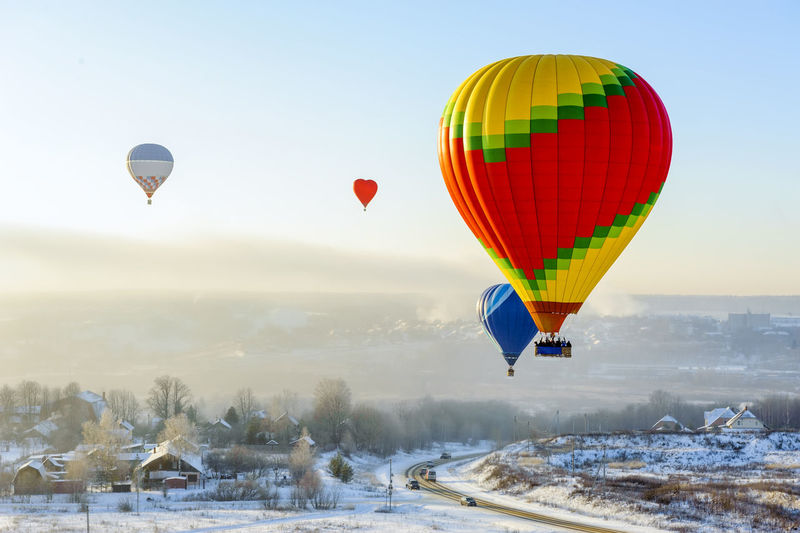 Hot air balloon flying over snow against sky