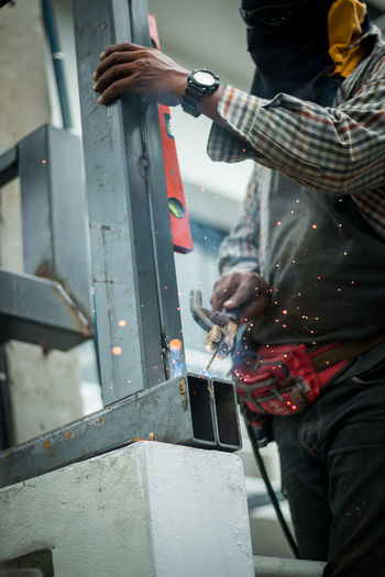 Midsection of worker welding metal