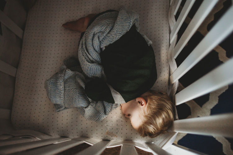 High angle view of boy sleeping on bed at home
