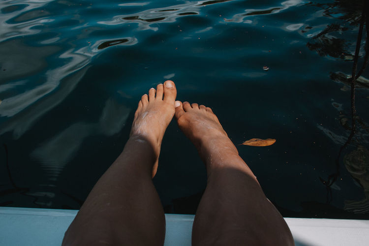Low section of woman relaxing in water