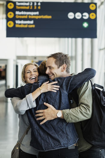 Happy business colleagues embracing at airport