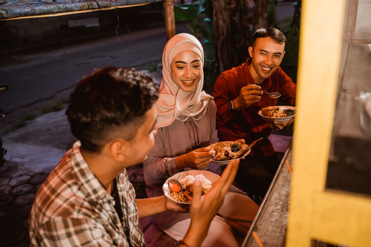 Smiling people having food at stall