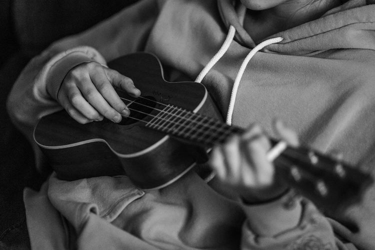 Midsection of man playing guitar
