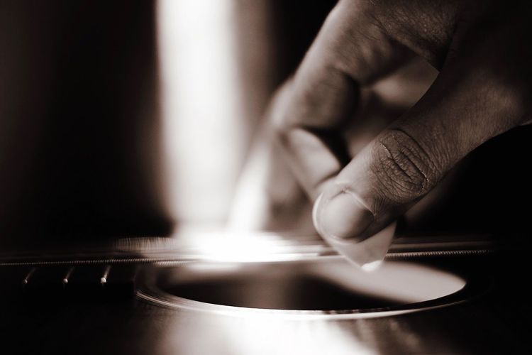 Cropped image of person playing guitar