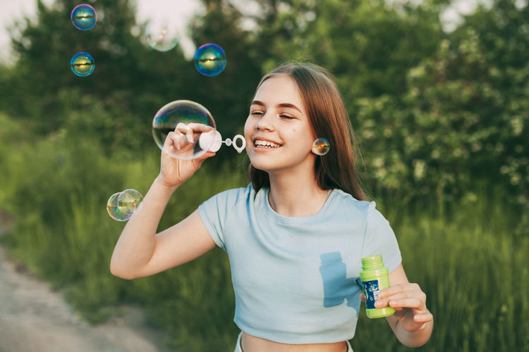 Cute girl making bubble outdoors