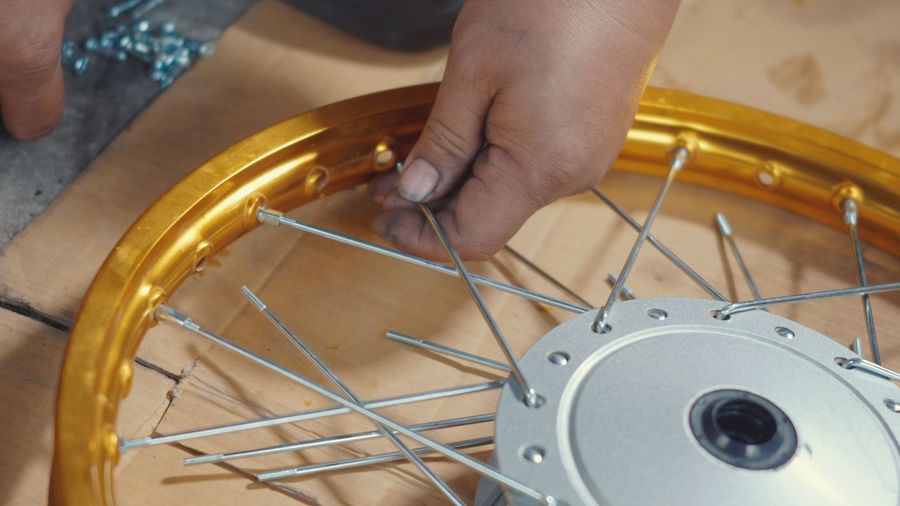 Cropped hand of man repairing wheel