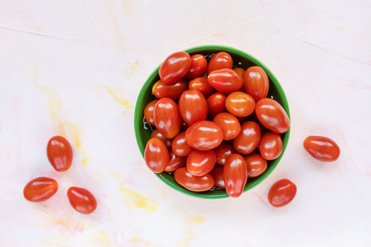 Fresh red cherry tomatoes in a bowl on light background. selective focus, copy space