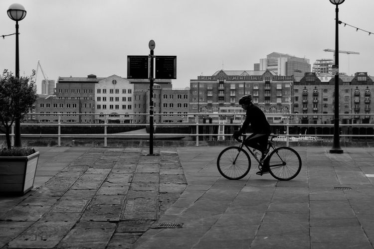 Rear view of man riding bicycle in city