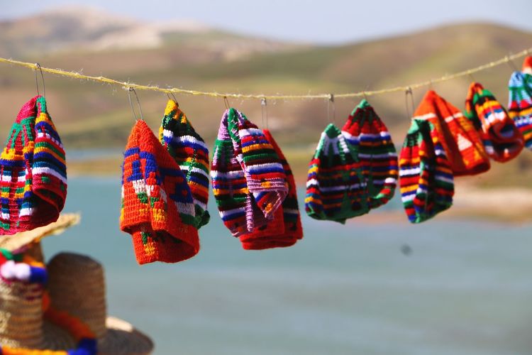 Close-up of multi colored hats hanging against sky in middle eastern