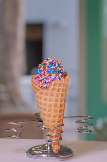 Close-up of ice cream cone with colorful sprinkles
