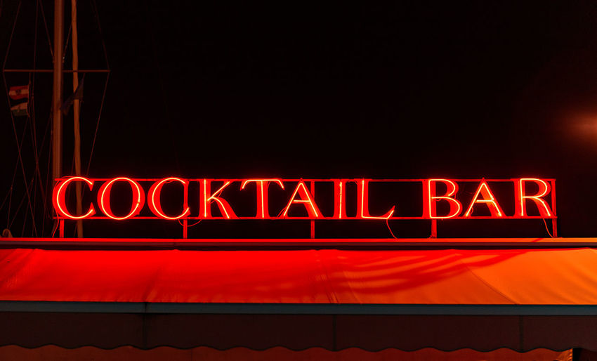 Red neon cocktail bar sign at night