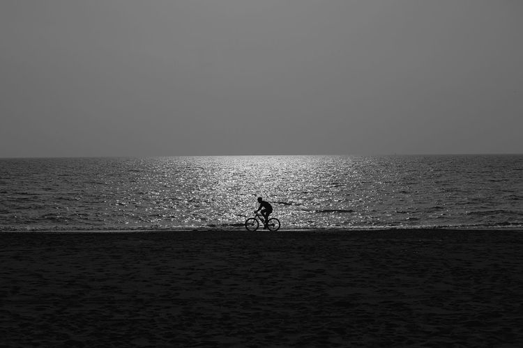 Silhouette man in sea against clear sky