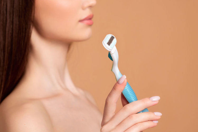 Midsection of woman holding razor