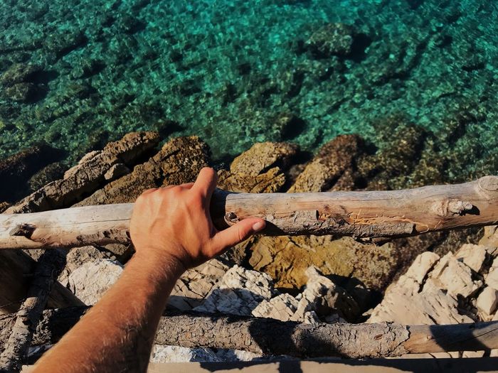 Cropped hand holding wooden railing