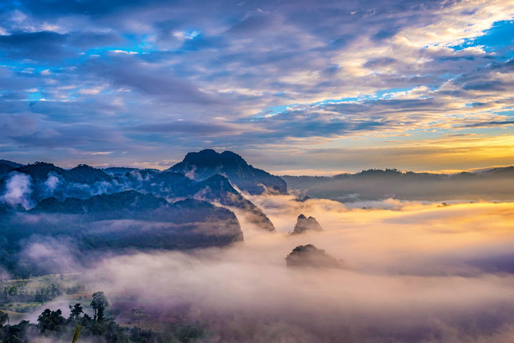 Scenic view of mountains against dramatic sky during sunset