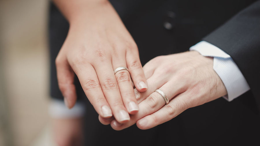 Midsection of couple showing wedding rings