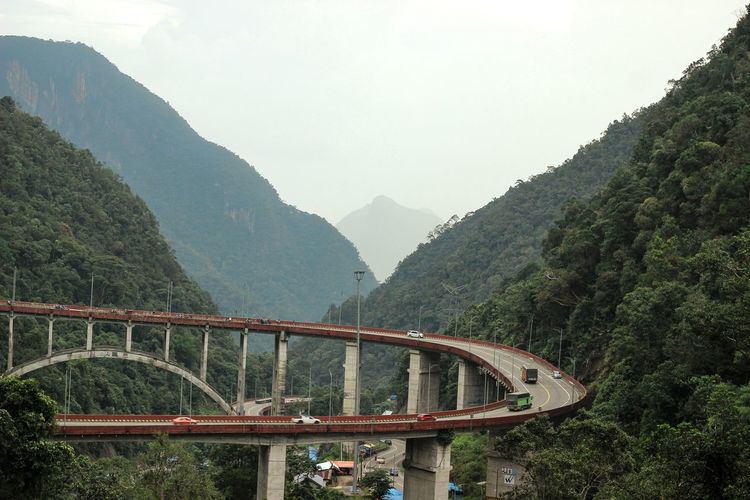 Bridge over mountains against sky