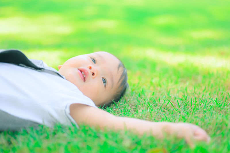 Portrait of baby girl lying on land