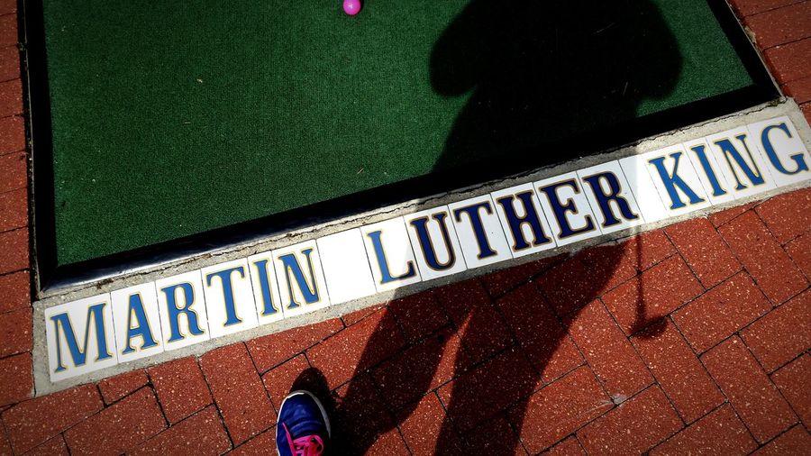 Low section of golfer standing by martin luther king text