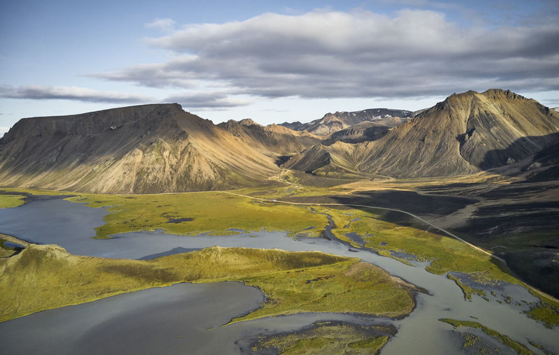 Marsh near mountains on cloudy day
