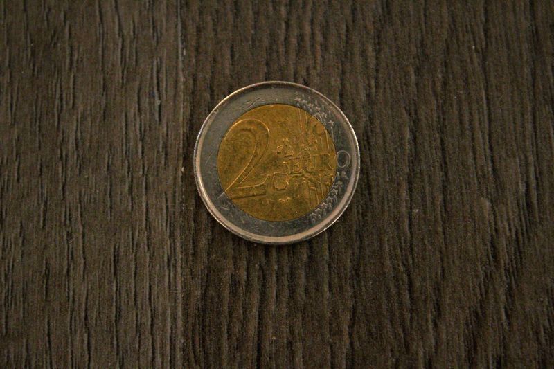 Close-up of two euro coin on wooden table