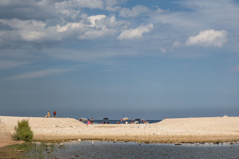People on beach against sky