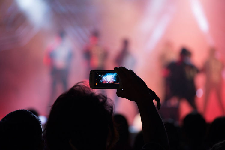 Group of people photographing music concert