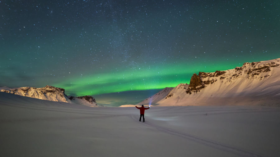 Person on mountain against sky at night