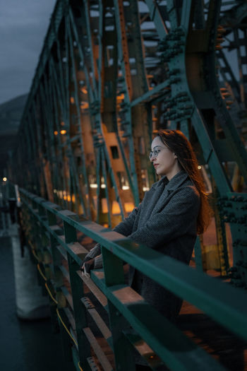 Woman looking at illuminated bridge
