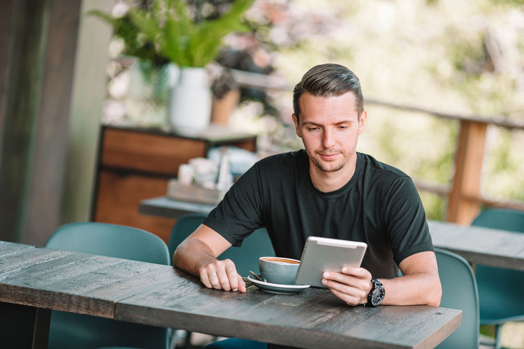 Man using digital tablet at cafe