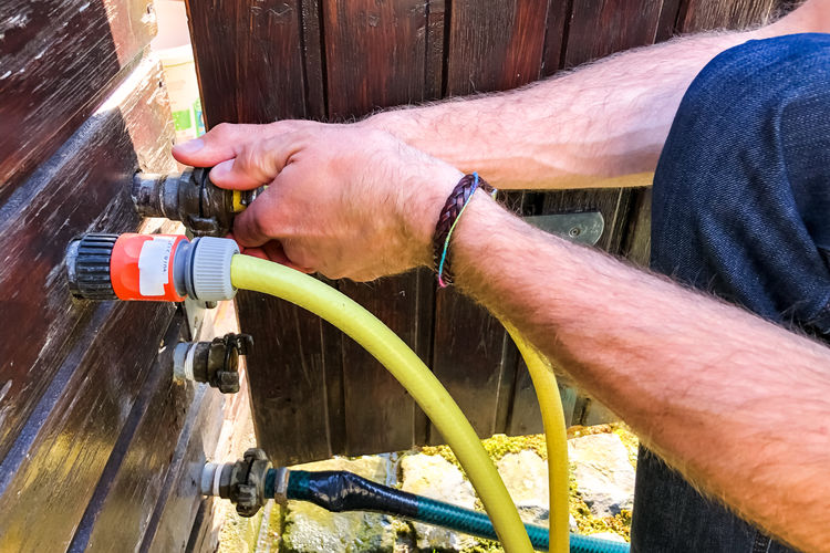 Cropped hands of man holding water pipe