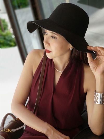 Fashionable woman wearing hat looking away in city