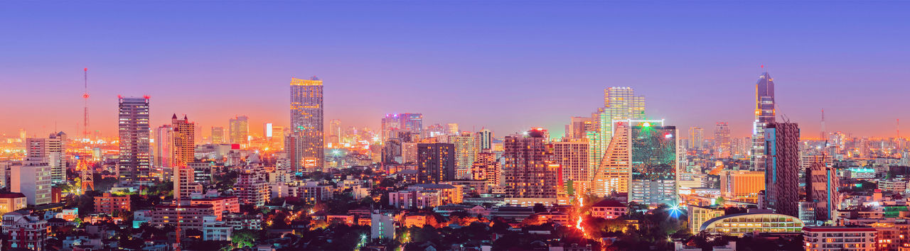 Panoramic view of illuminated city buildings against sky