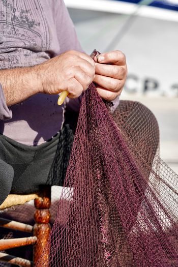 Midsection of man holding fishing net