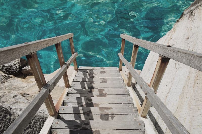 Wooden stairs leading to calm water