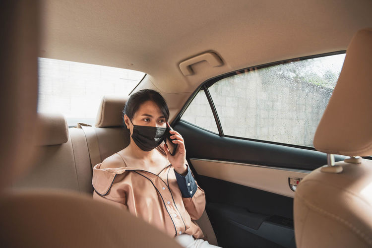 Woman using mobile phone while sitting in car