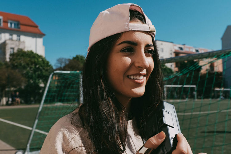 Architecture Close-up Communication Day Focus On Foreground Front View Headshot Leisure Activity Lifestyles Millennial Pink Mobile Phone One Person Outdoors Real People Smiling Technology Wireless Technology Young Adult Young Women