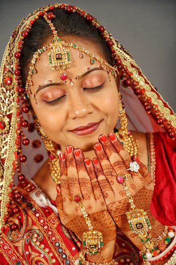 Close-up of smiling bride praying against wall at home
