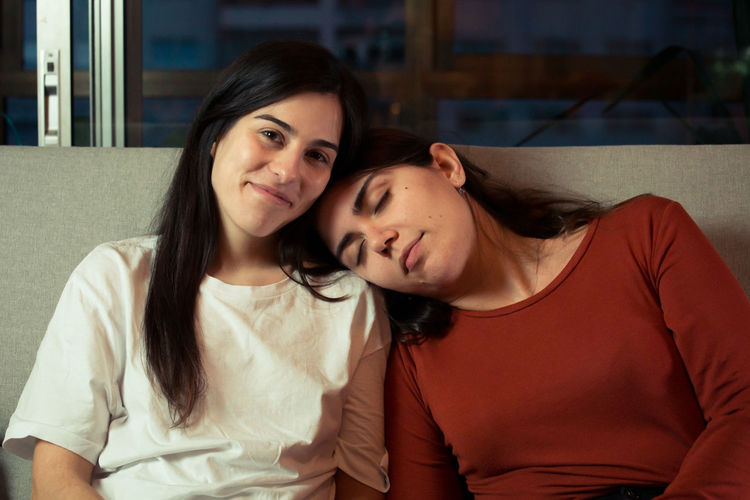 Young women relaxing on sofa at home